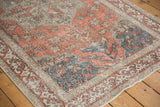 Distressed Sivas rug corner detail: terra cotta and dusty blue floral vinery with worn pile.