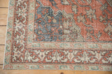 Distressed Sivas rug corner, terra cotta field, dusty blue vinery, and beige borders.