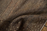 Distressed Oushak carpet pile showing even wear and speckled sand, beige, brown tones.