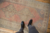 Distressed vintage Oushak rug with faded stepped medallion in dusty blush, pale gray, ivory.