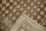 Distressed Oushak rug corner revealing abrashed lattice, secure side selvage, and hand-knotted foundation.