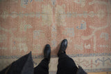 Vintage distressed Oushak rug showing blush, ivory, and dusty blue with visible wear.
