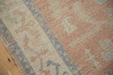 Distressed blush, ivory, blue vinery pattern and mostly even wear on Oushak rug.
