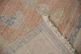 Distressed Oushak rug pile with mostly even wear, visible foundation, and cream fringe.