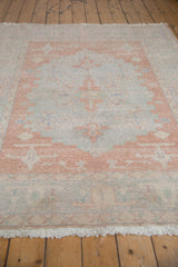 Textural vintage Oushak rug detail showing Samovar design in pale blush, powder blue, and fringe.