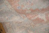Distressed Oushak carpet texture in blush, pale blue, and ivory, showing mostly even pile wear.