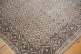 Distressed Sparta rug corner: geometric border and lattice field in oxidized silver, ivory, sand.