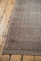 Corner of a distressed vintage Sparta rug, showing intricate diamond lattice and mostly even wear.