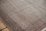 Corner of a distressed Sparta rug showing diamond patterned border and neutral allover field.
