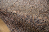 Intricate diamond lattice pattern on the textured pile of a rolled vintage Sparta rug.