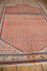 Vintage Mir Sarouk rug's madder red germinating plant field with Serbend border, showing even wear.