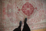 Distressed vintage Oushak carpet, pale cherry red floral motifs, mostly even wear.