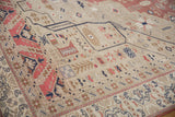 Low, even pile of a distressed Oushak rug with blush and blue floral motifs.