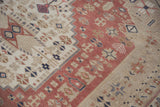Evenly worn pile of a hand-knotted Turkish Oushak with blush, beige, and ivory motifs.