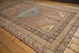 Faded aqua blue medallion, distressed chestnut brown field, and varied geometric borders.