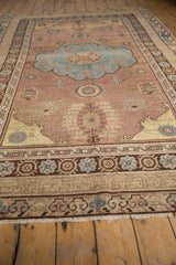 Faint foundation showing through the distressed weave and fringe of a vintage Khotan rug.