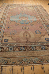 Distressed fringe and geometric borders in brown, aqua, beige on vintage Khotan rug end.