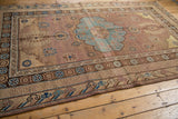 Khotan carpet border detail with geometric and floral patterns in muted aqua and brown.