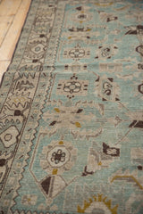 Angled view of a vintage Hamadan rug's low pile, highlighting the seafoam green and sand floral pattern.