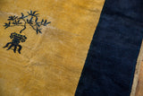 Peking carpet detail: saffron field with dark blue potted plant and indigo border.