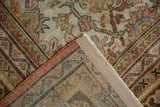 Distressed Mahal carpet folded corner, revealing worn floral-leaf design and hand-knotted reverse.