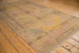 Vintage distressed Khotan rug corner, showing saffron yellow, beige, and blush faded patterns.