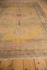 Distressed vintage Khotan carpet end, showing worn pile, exposed foundation, and fringe.