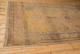 Distressed Khotan carpet end with visible wear to foundation, showcasing restored outer border.