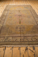 Worn fringe and dark brown stylized border pattern on a vintage distressed Khotan carpet.