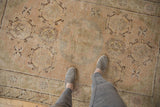 Distressed Khotan rug with faded allover patterns and visible low pile texture.