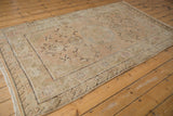 Distressed vintage Khotan rug, showcasing soft allover pattern and time-softened beige and blush hues.