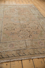 Distressed Khotan rug corner, displaying low pile, foundation, beige tones, and fringe.