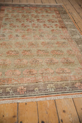 Distressed beige and pale orange germinating plant lattice on a vintage Khotan rug.