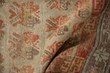 Distressed Khotan rug showing worn germinating plant motif in beige, pale orange, and silver tones.