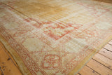 Vintage Oushak carpet corner spandrel with worn floral motifs in terra cotta and ivory.