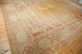 Vintage Oushak carpet corner with terra cotta floral spandrel and worn gold field.