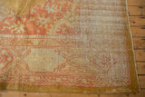Vintage Oushak carpet corner with faded floral border, saffron gold selvage, and exposed knot heads.