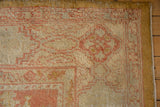 Vintage Oushak rug corner with oversized terra cotta floral spandrel and gold selvage.