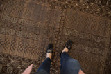 Vintage Belouch rug: geometric germinating plant motifs, knot head wear in brown, beige, oxidized silver.