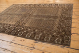 Vintage Belouch rug corner, featuring geometric germinating plant motifs in coffee brown and ivory tones.