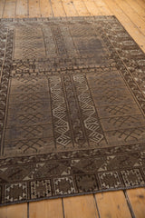 Finned geometric plant motifs and textured brown and beige pile of a Belouch rug.