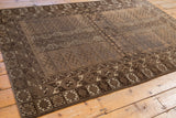 Vintage Belouch rug corner showing finned germinating plant motifs in brown and beige.