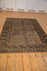 Vintage Belouch rug's geometric border and compartmentalized plant motifs in brown and ivory.