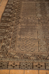 Vintage Belouch rug detail: geometric finned plant motifs in coffee brown, beige, and ivory.