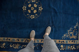Peking carpet's deep indigo field and beige border with floral vinery and blossoms.