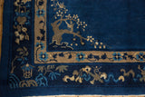 Peking carpet border with whimsical tree and bird motifs in indigo and beige.
