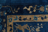 Peking carpet corner detail: indigo field, beige floral border, pictorial motifs, speckled wefting.