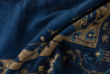 Deep indigo blue pile with delicate beige floral vinery on folded vintage Peking carpet.