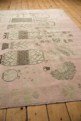 Distressed pink field of the vintage Khotan rug displaying mostly even wear and muted designs.