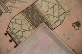 Vintage Distressed Khotan rug corner showing pink and beige pile with its hand-knotted foundation.